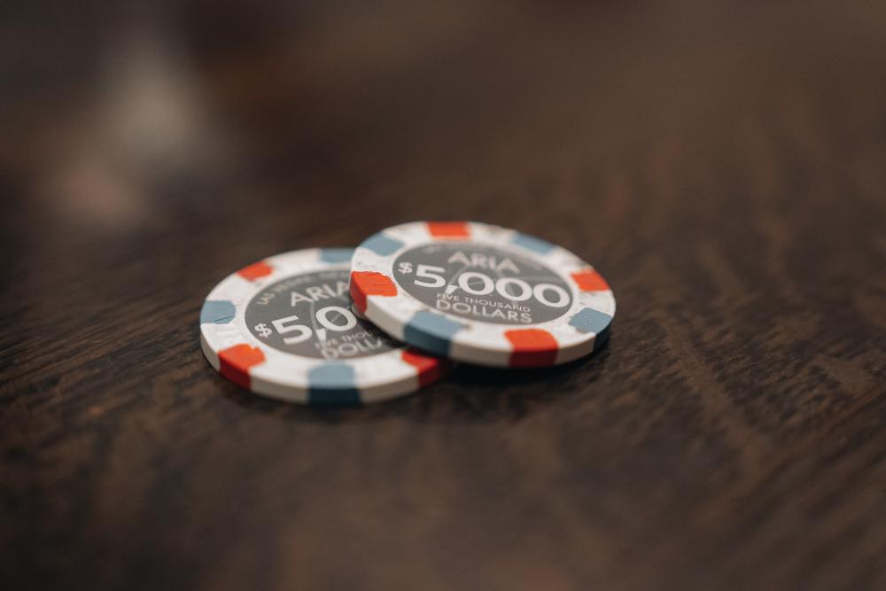 duas fichas de poker em cima de uma mesa de madeira